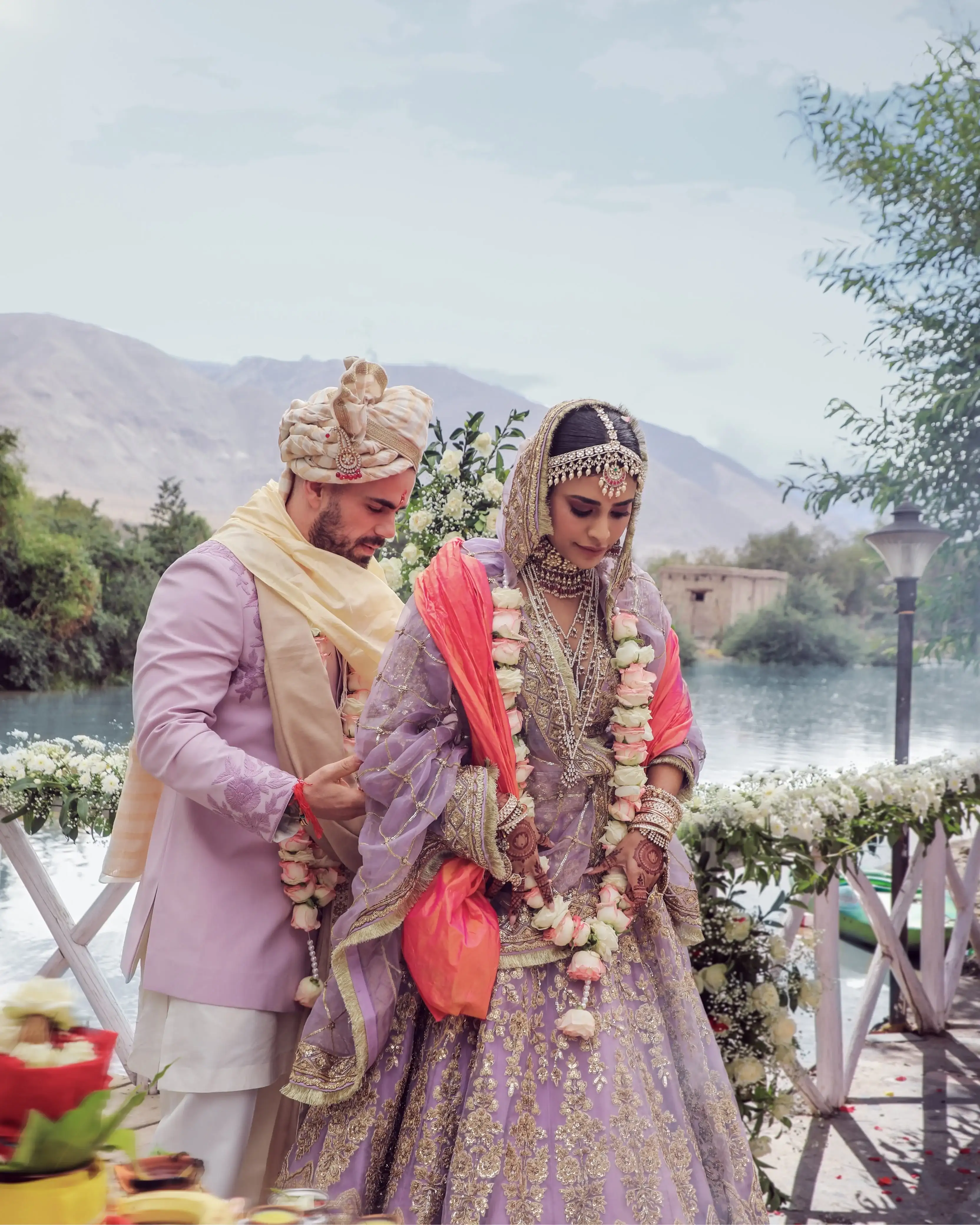 Groom fastening the rose garland during the jaimala
