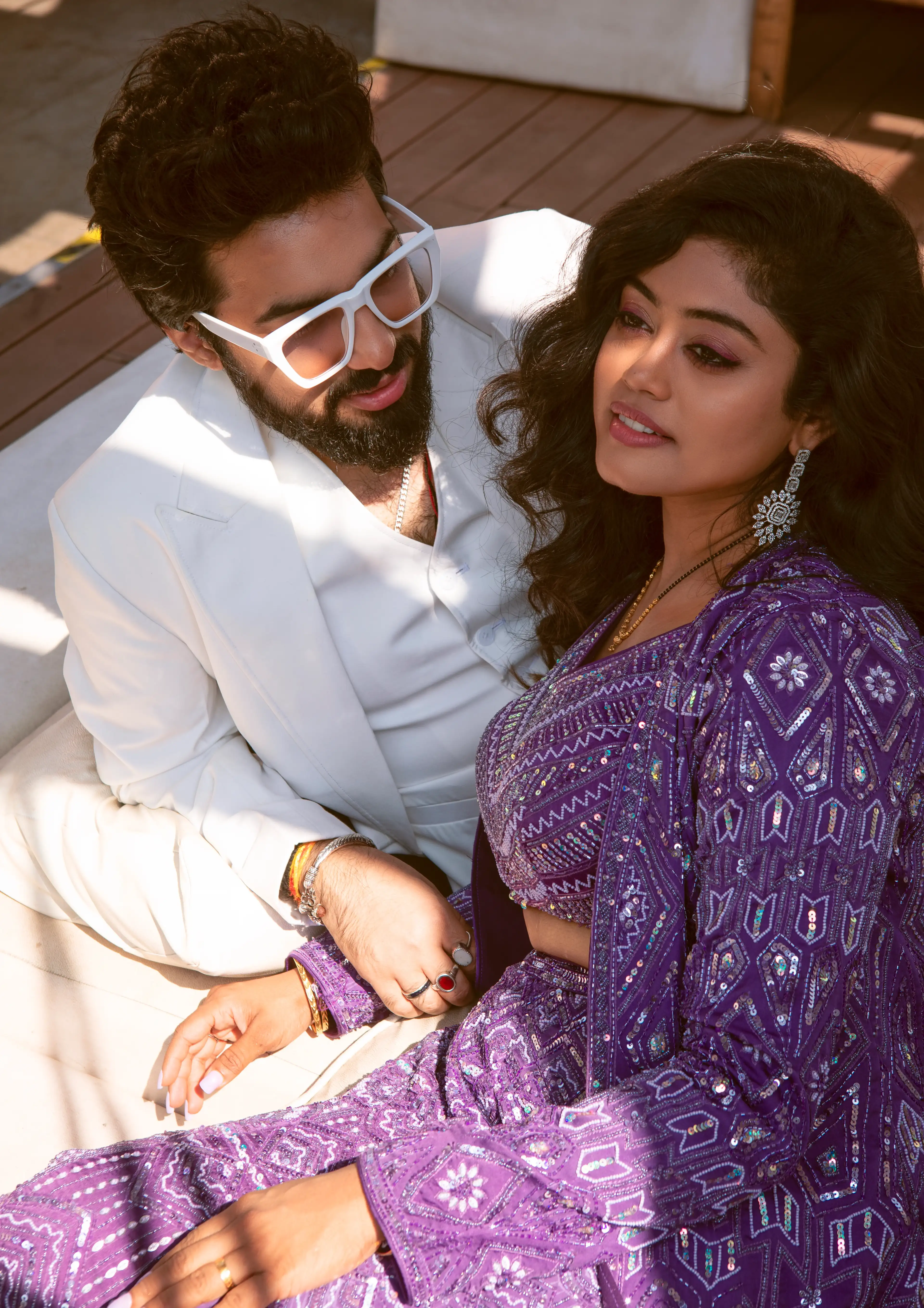 Couple in a white suit and purple sequinned lehenga in golden sunlight