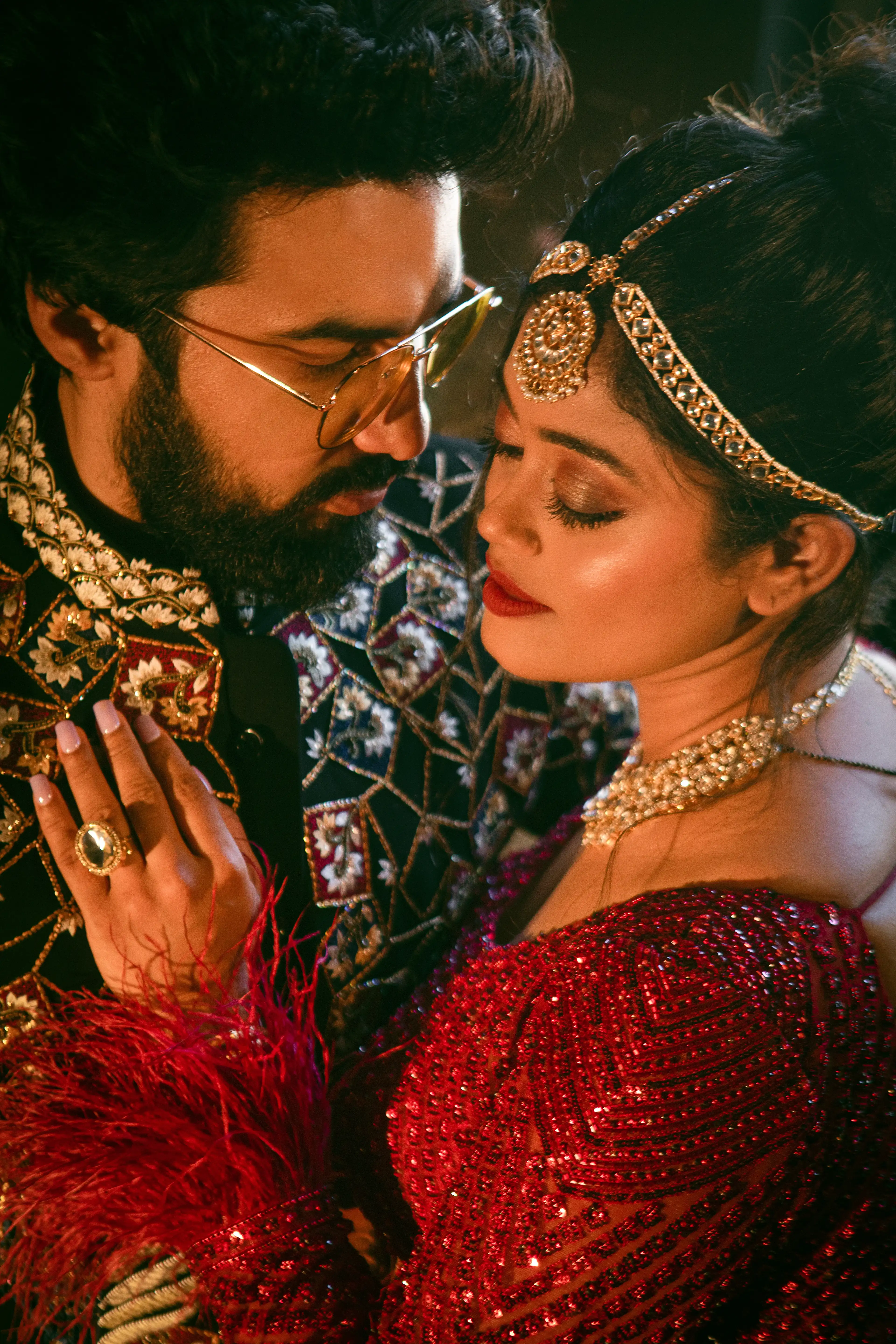 Close-up of a couple in a maroon sequinned lehenga and embroidered sherwani