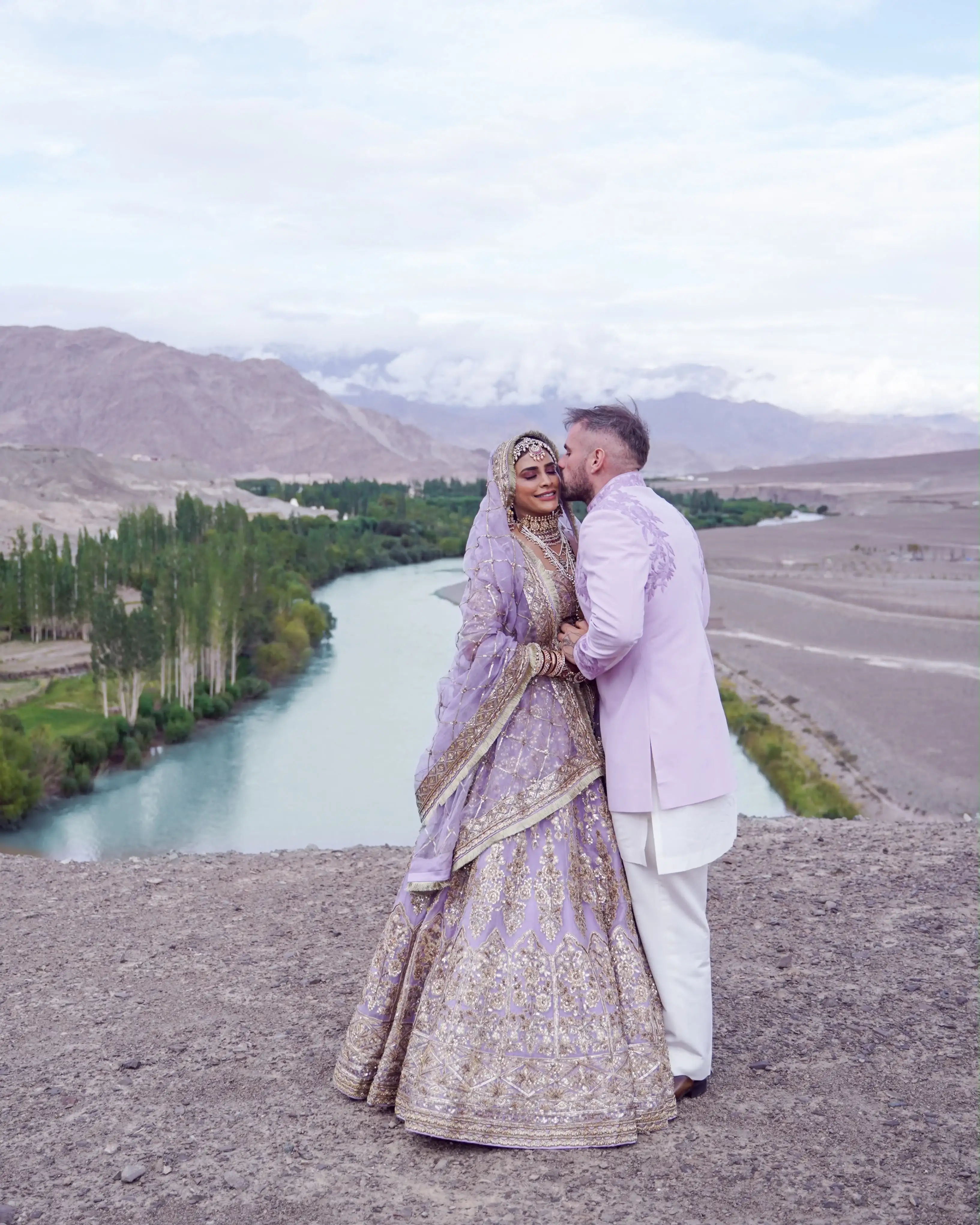 Groom kissing the bride above the river bend, Ladakh